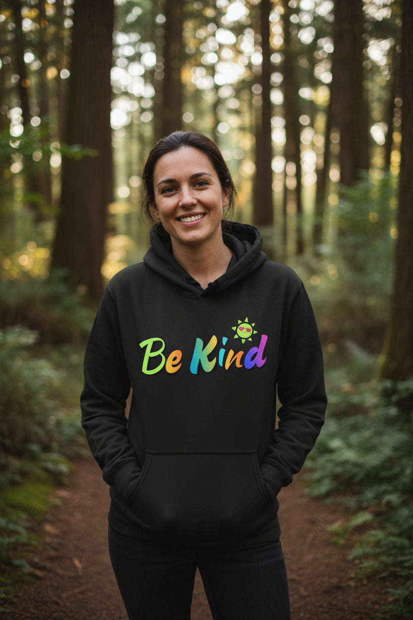 A dark charcoal gray pullover hoodie with a colorful graphic on the chest that reads 'Be Kind' in a rainbow gradient, accompanied by a small smiling sun character. The hoodie is shown against a plain white background.
