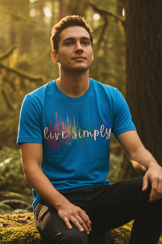 A bright blue short-sleeve t-shirt with a colorful graphic on the chest. The graphic features the phrase 'live simply' in white script over a vertical multicolor soundwave design.